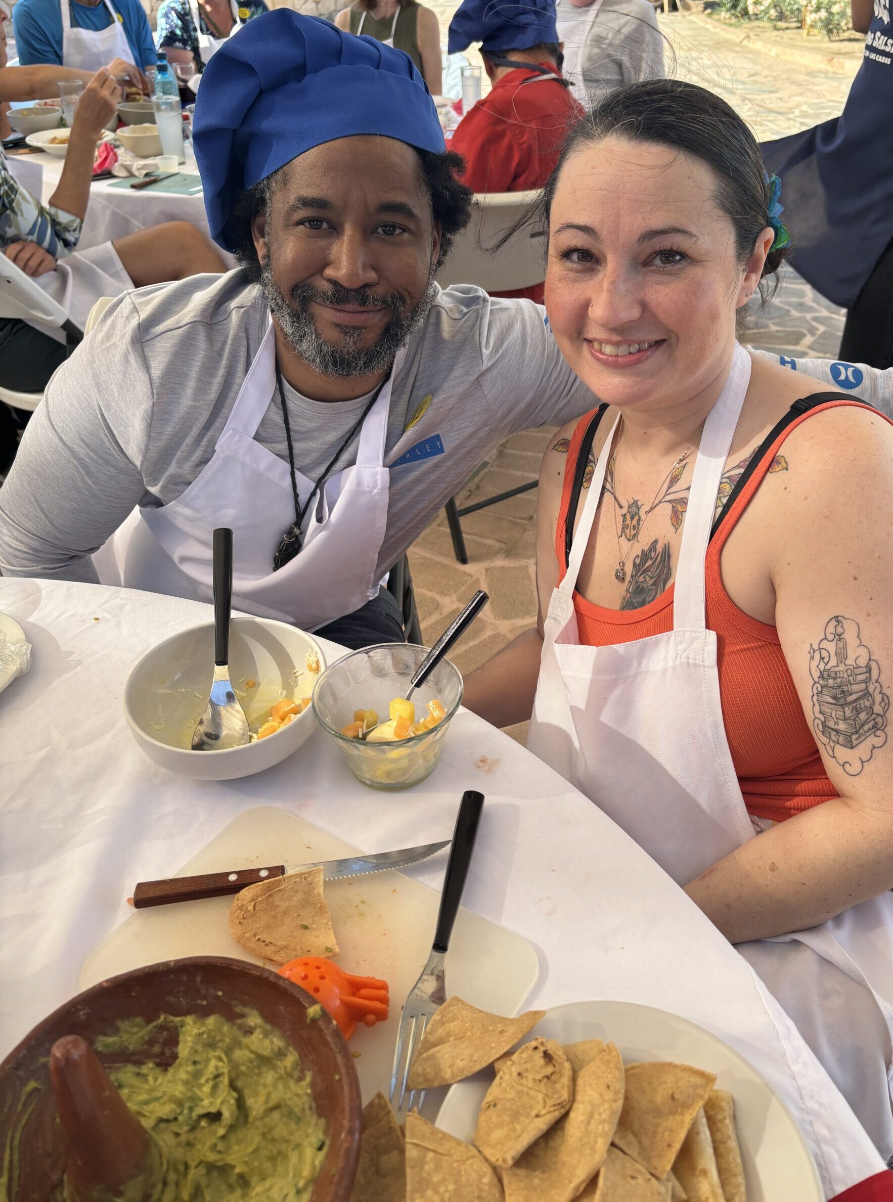 Couple in aprons and chef hats at a salsa-making class in Cabo San Lucas