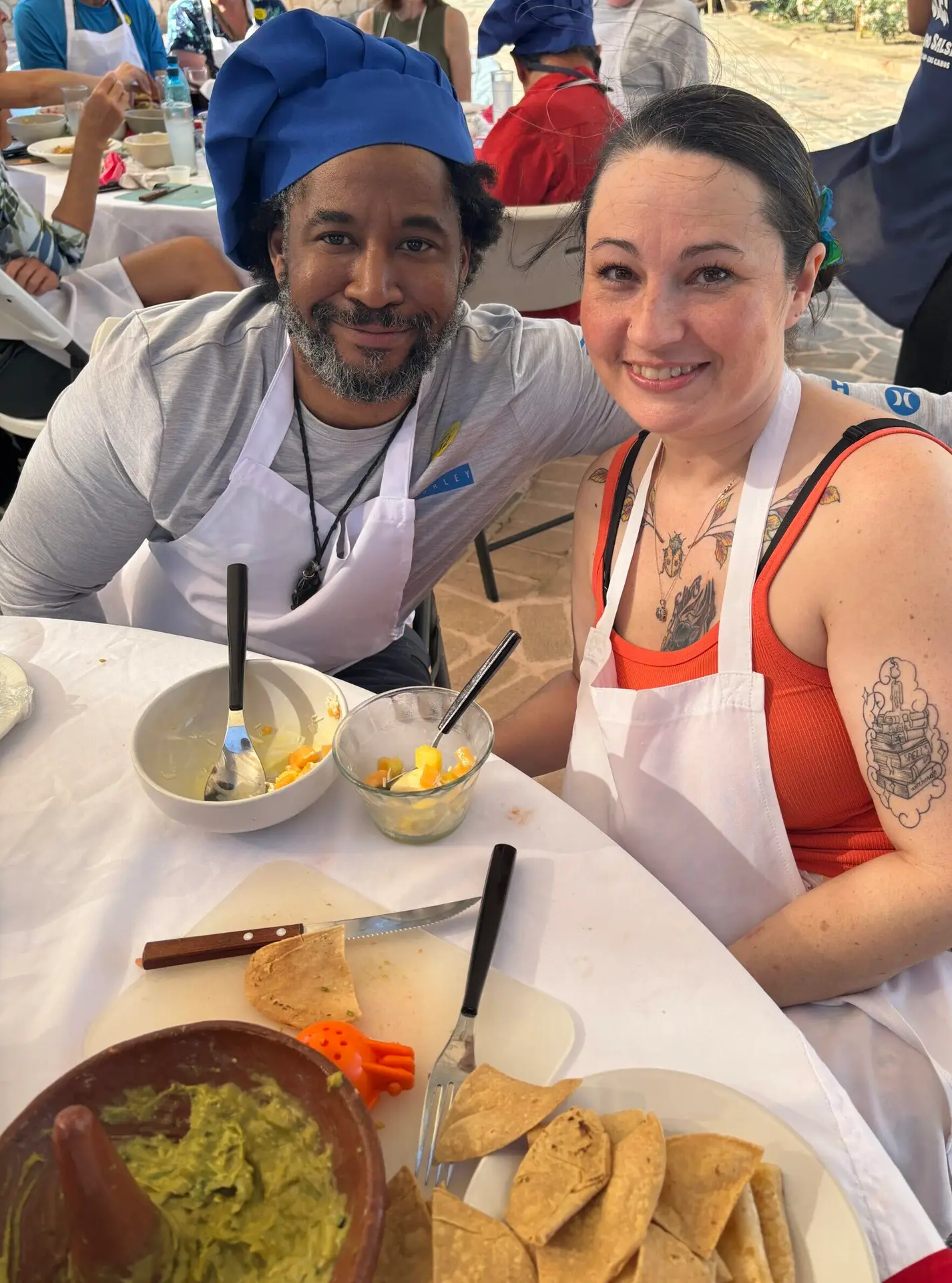 Couple in aprons and chef hats at a salsa-making class in Cabo San Lucas